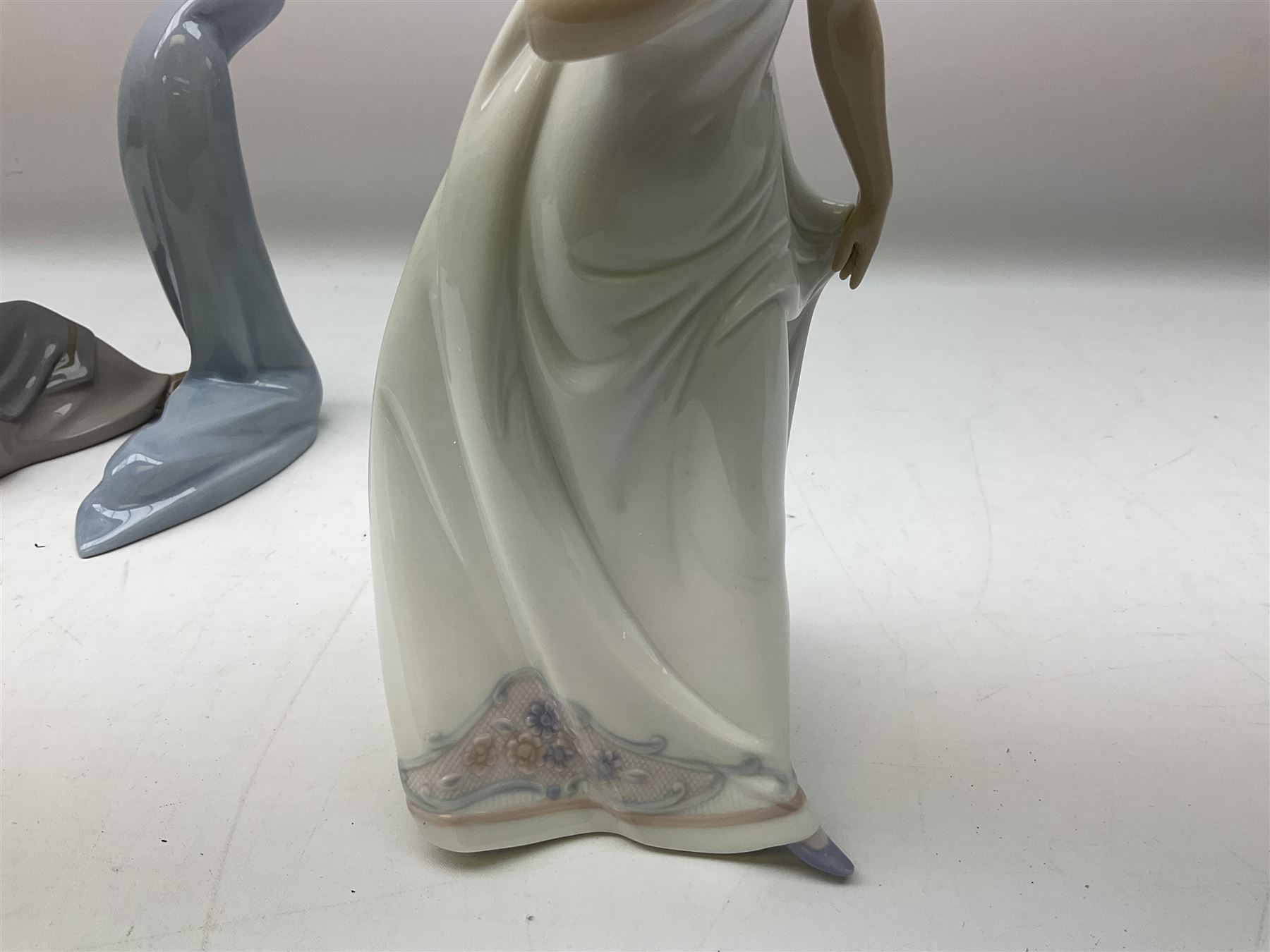 Four Lladro figures, comprising Afternoon Promenade no 7636, Nostalgia no 5071, both with original boxes, Girl with Lilies no 4972 and Madonna no 4534, largest example H27cm