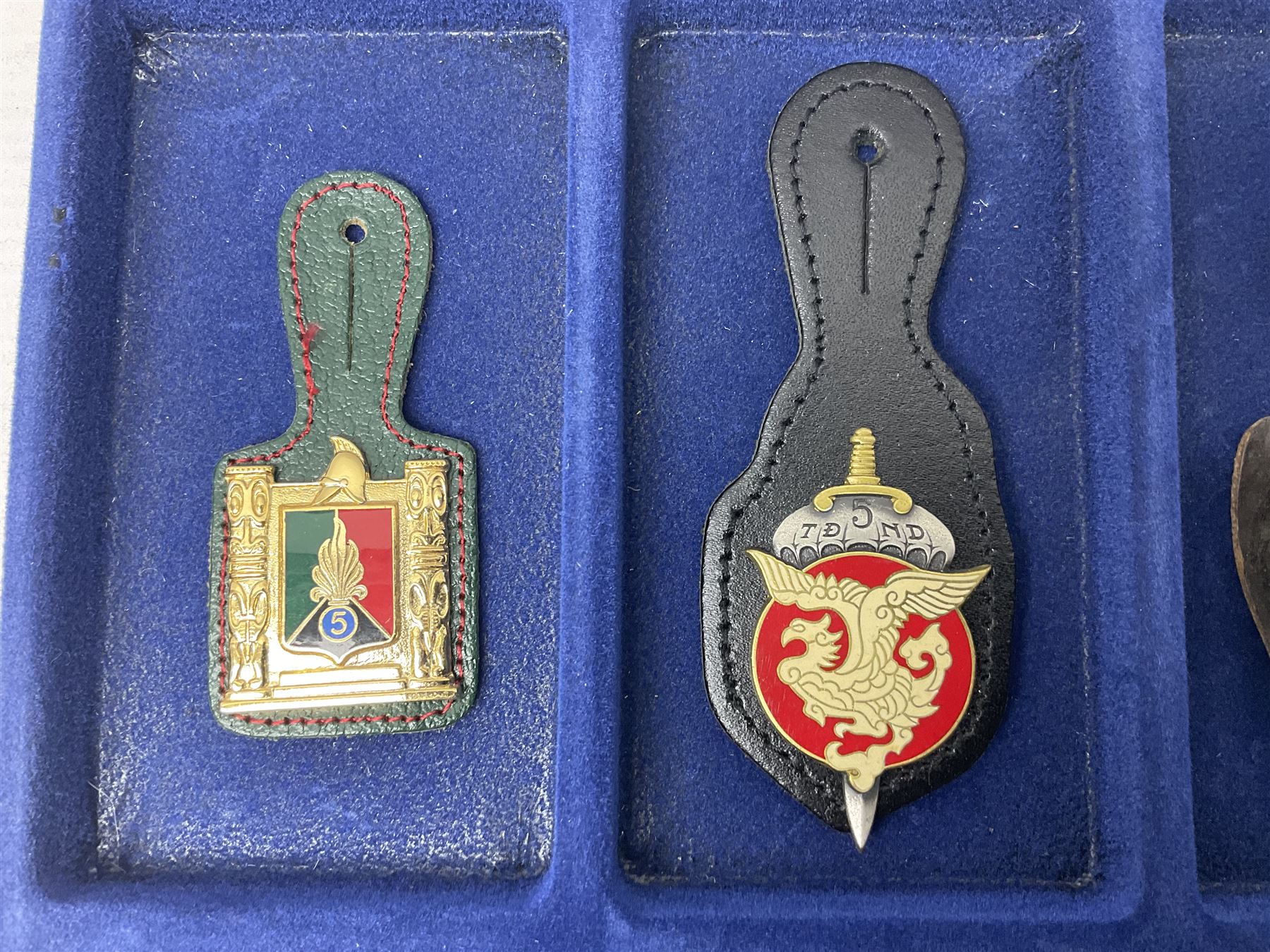 Twelve French military metal badges mounted on leather fobs including Legion, Artillery, Parachutist, Air Force, Infantry etc