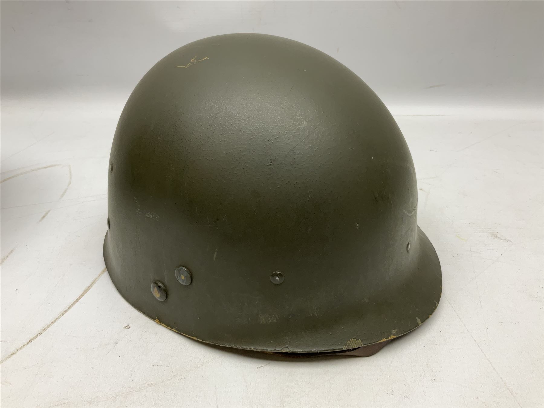 American first type paratrooper helmet with post-WW2 strap and D-rings and later 1944 liner bearing Firestone Tyre and Rubber Company mark; green textured finish