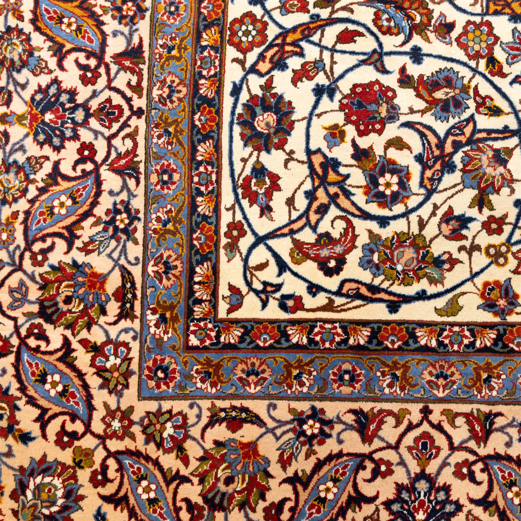 Central Persian Najafabad hand-knotted carpet, ivory field with an all-over scrolling floral design of palmettes, rosettes, and leafy vine work, enclosed by a wide floral main border flanked by multiple guard borders in madder red, indigo blue, green, and pale ochre, with cotton fringe ends 