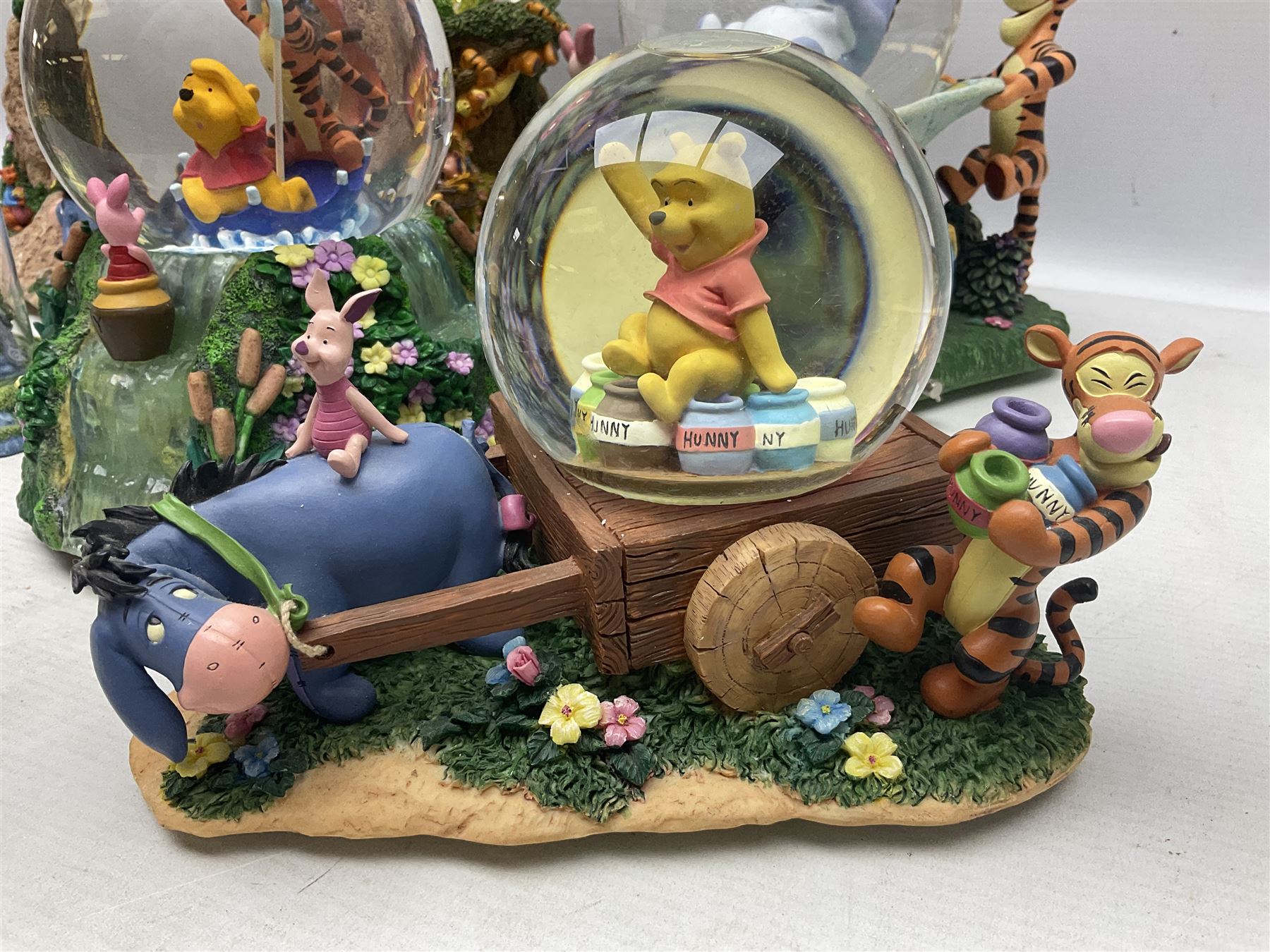 Five Disney Winnie The Pooh snow globes to include The Rain Rain Rain Came Down Down Down, Eeyore Pulling Cart, Owl's House, Rumbly in My Tumbly and Stuck In Rabbit's House, together with figure group with dome, five with boxes (6)