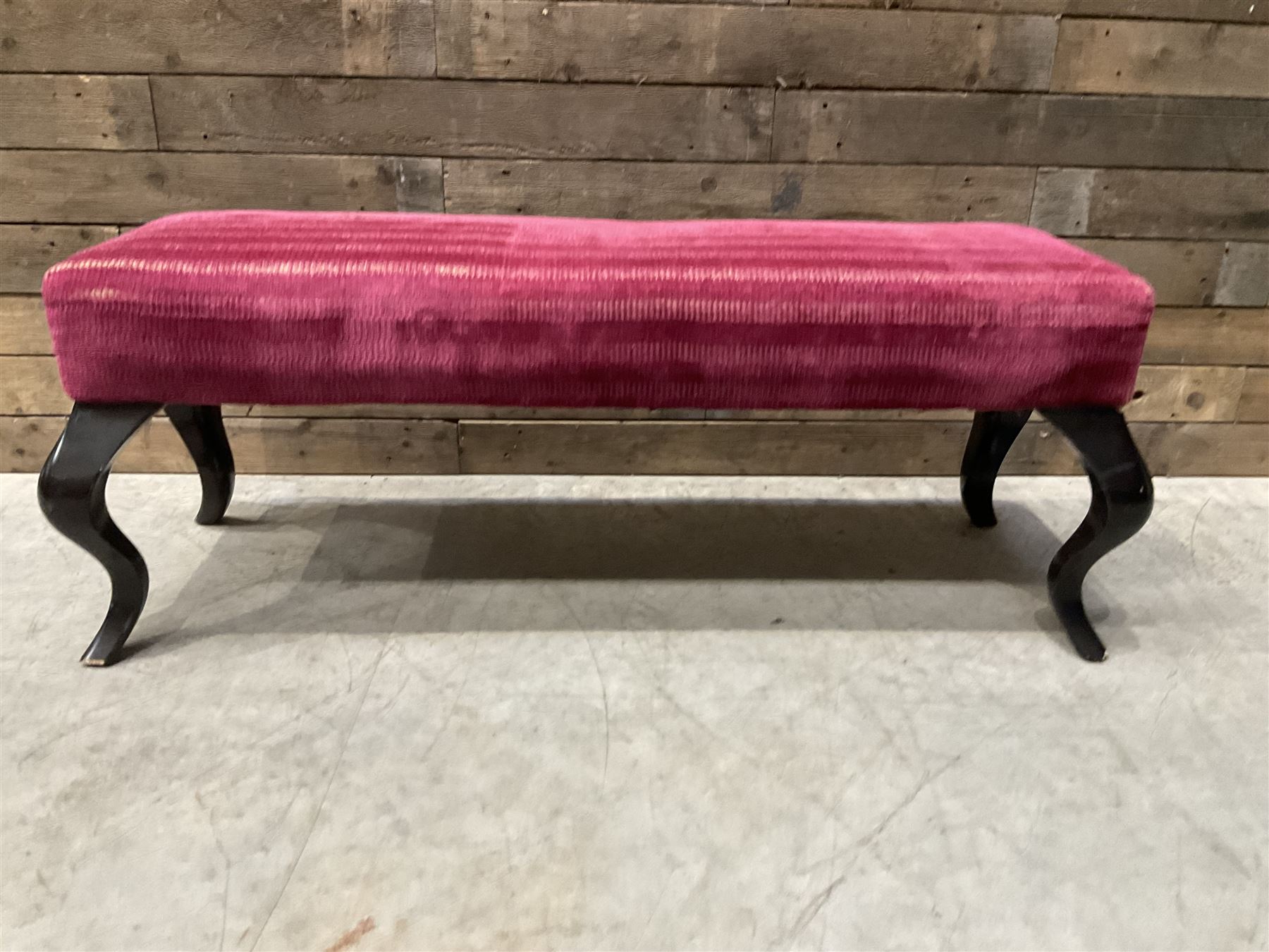 Large rectangular footstool upholstered in a maroon fabric with cabriole supports
