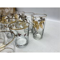 Mid 20th century glass part lemonade set comprisimg jug decorated with white floral sprays and gilt banding with three matching cups, together with a set of six tumblers decorated in black and gilt with flowers and set of four other glasses