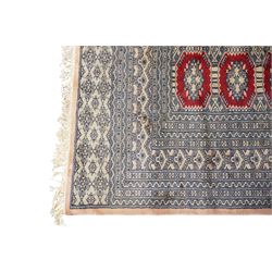 Jaldar Bokhara crimson and pale ground carpet, the field decorated with five rows of Gul motifs, within intricate multi-band border decorated with repeating geometric designs 