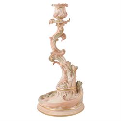 Royal Worcester pair of blush ivory candlesticks, modelled in the rococo style of scrolling foliate design upon a circular spreading base, gilt-heightened, puce mark to base and numbered RN160134 and 1478, H32cm