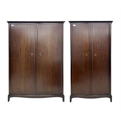 Stag Minstrel - pair of mahogany double wardrobes, comprising a larger wardrobe with a shelf and hanging rail behind two panelled doors (W127cm, D59cm, H177cm); and a smaller wardrobe enclosing a single hanging rail (W96cm, D59cm, H177cm), both finished with projecting cornices and raised on bracket feet




