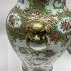 Pair of 19th century Chinese Famille Rose vases and covers, each of baluster form with twin gilt lion mask ring handles to shoulders, the flattened domed covers with gilt temple lion finials, each decorated with alternating reserves of bijin and attendants, and birds and butterflies amongst blossoming peonies, against a gilt ground profusely decorated with stylised scrolls, H32.5cm