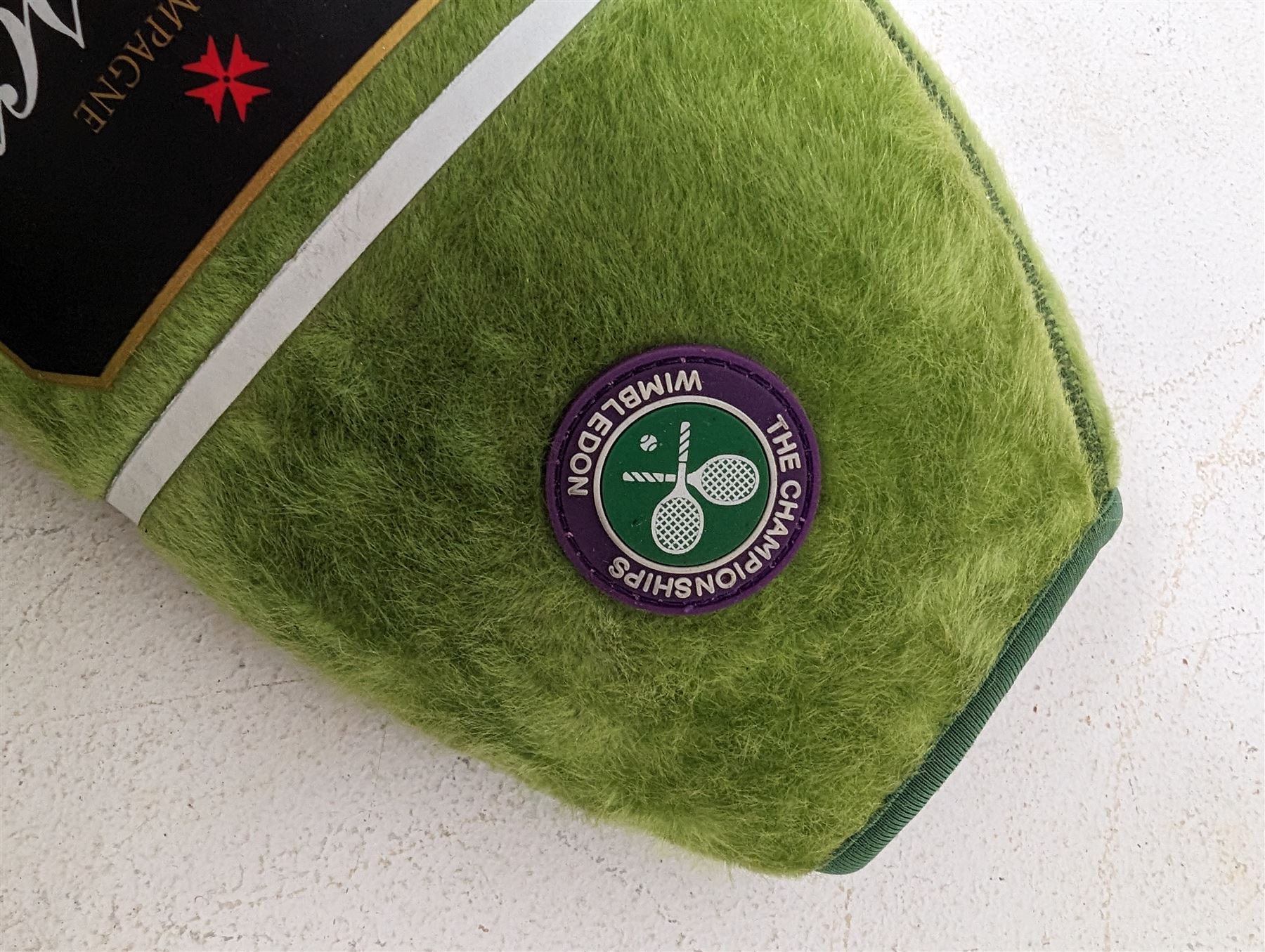 Three tennis balls, two with indistinct signatures, in Wimbledon Lansons Champagne cooler case