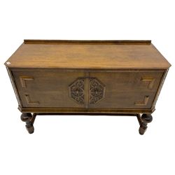 Early to mid-20th century oak two door sideboard, decorated with applied mouldings and octagonal foliage scrolled mount