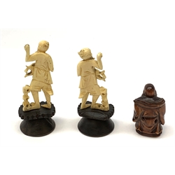 Two carved bone figures, each modelled as a fisherman with catch, overall H9cm, together with a Japanese wooden Netsuke modelled as a hotei, signed beneath, H5cm. 
