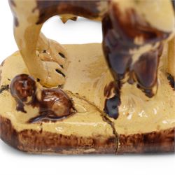 Early 19th century pottery model of a cow with drab colouring accompanied by a standing figure and a dog on naturalistic base, possibly South Yorkshire L14cm x H14cm