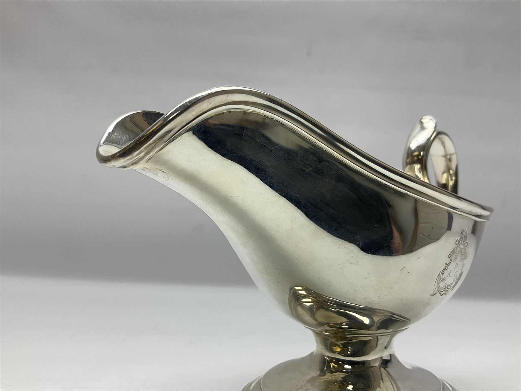 Christofle silver-plated sauce boat, of typical plain form, with capped C scroll handle and engraved anchor crest to body, upon a stepped oval foot, stamped 22 Christofle to base, including handle H14cm