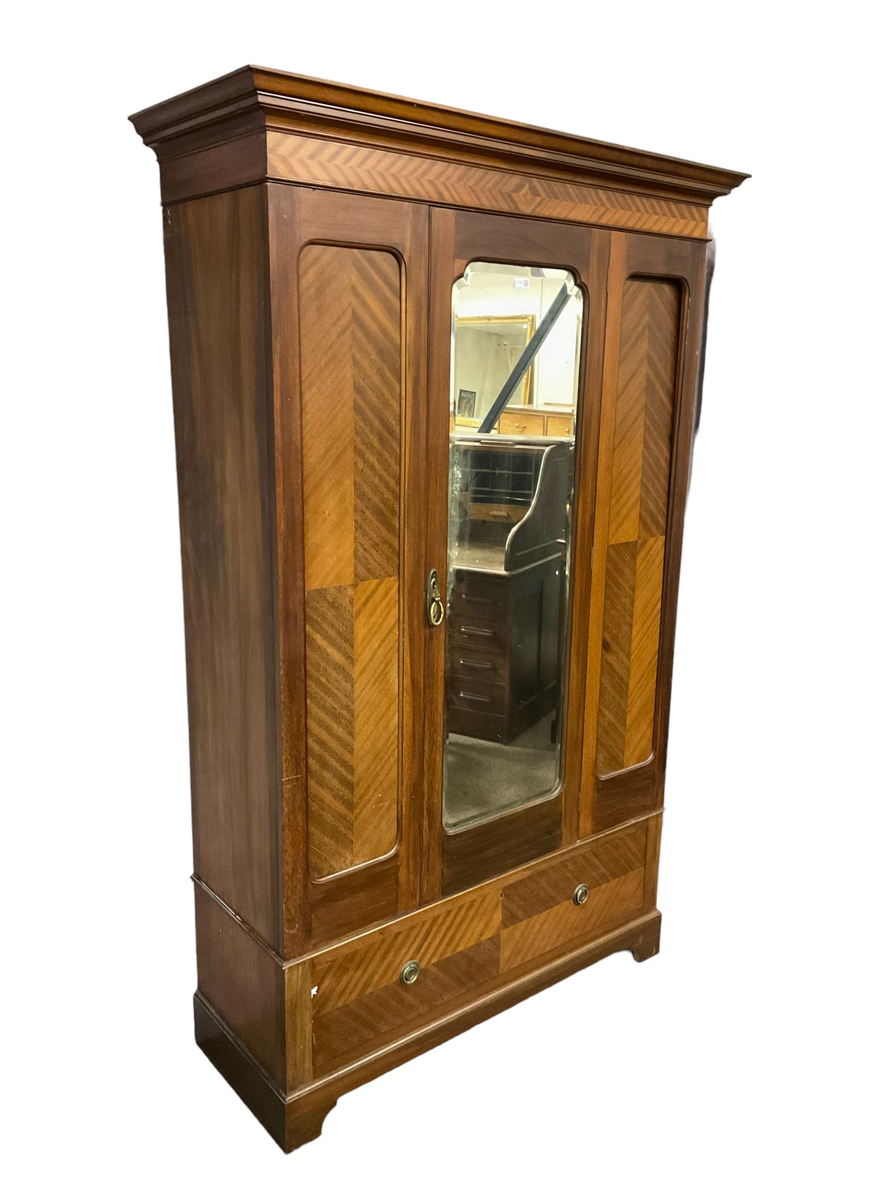 Edwardian mahogany single wardrobe, figured matched veneers to frieze, drawer front and panels, enclosed by bevelled mirror glazed door, base fitted with single drawer, on bracket feet