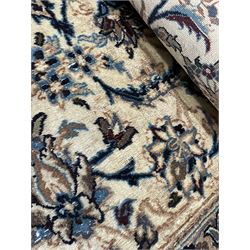 Persian Kashan ivory ground carpet, central rosette medallion surrounded by swirling leafy branches and floral sprays, the main border with scrolling pattern interspersed with floral motifs, within guard stripes 