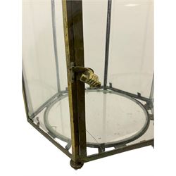 19th century brass and clear glass hexagonal hall lantern, with scrolling wire work open domed top over six arched panels, including a hinged door, the base enclosed with a circular glass panel on turned feet, H64cm