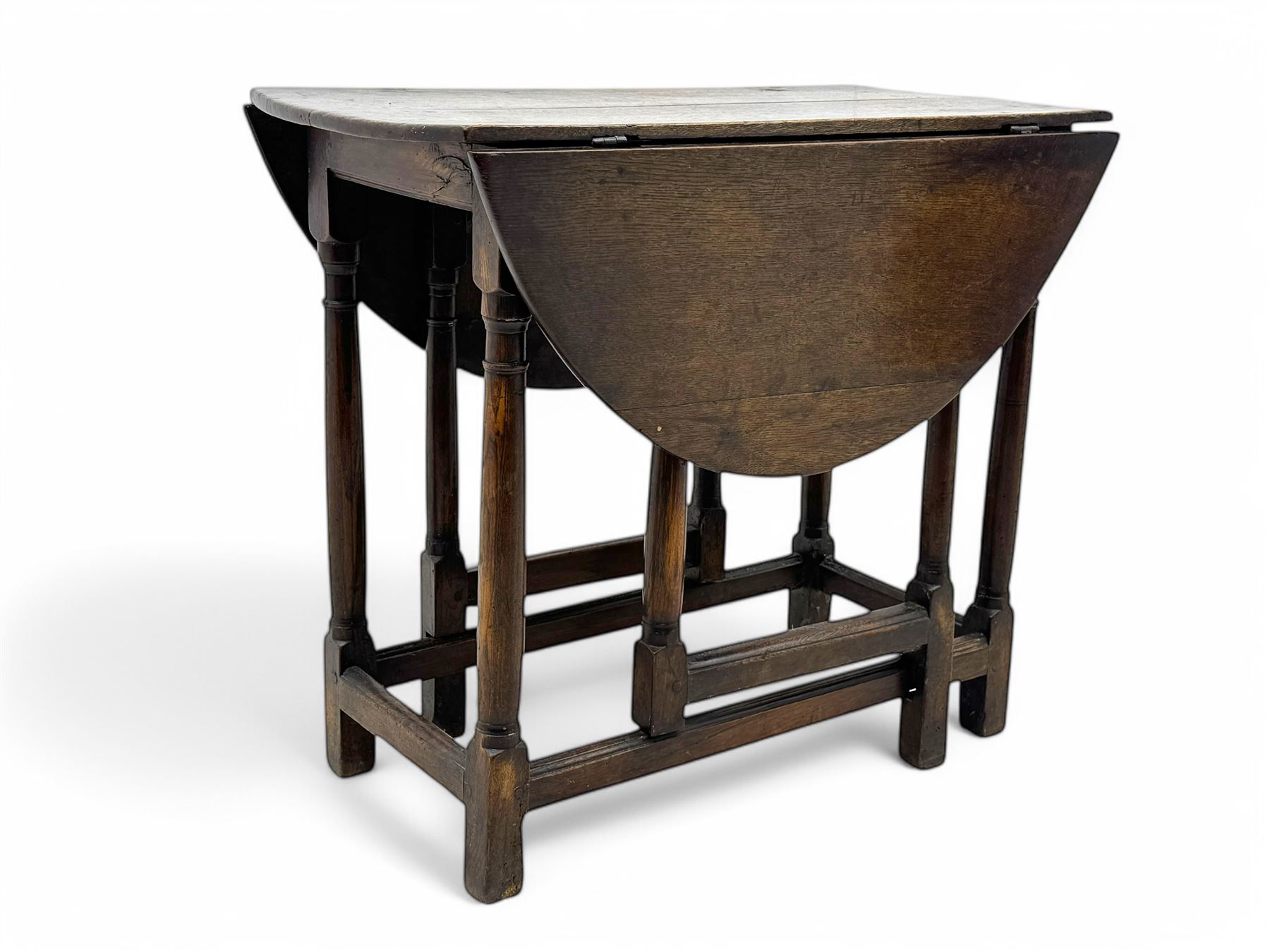 19th century oak gateleg table, the oval drop-leaf top formed of four planks, on turned column supports united by rectangular stretchers