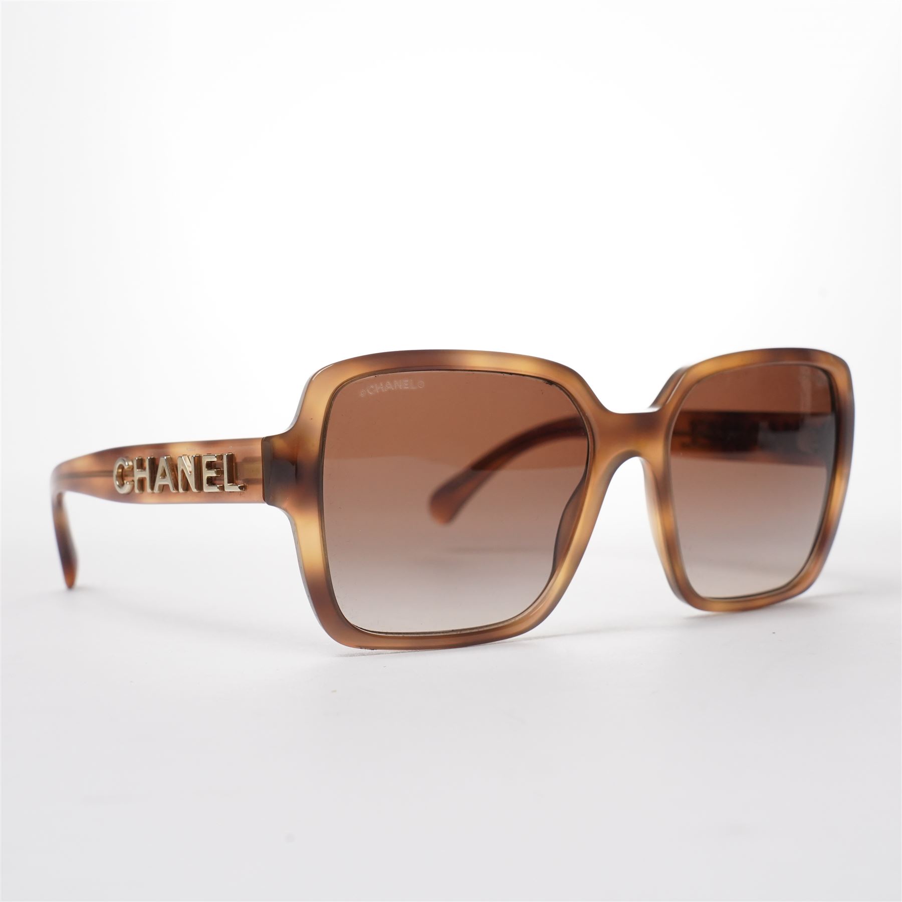 Chanel - pair of oversized sunglasses, with translucent tortoiseshell-effect brown acetate frames and gradient tinted lenses, the arms boldly set with gold-tone ‘CHANEL’ lettering, with original quilted leather case, booklet and box