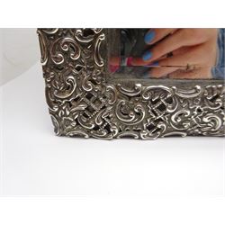 Early 20th century continental silver mounted dressing table top mirror, of rectangular form, the frame embossed with vacant reserve, lattice work, flower heads and C scrolls, with easel style support verso, unmarked but tests as silver, overall H49.5cm W31.5cm