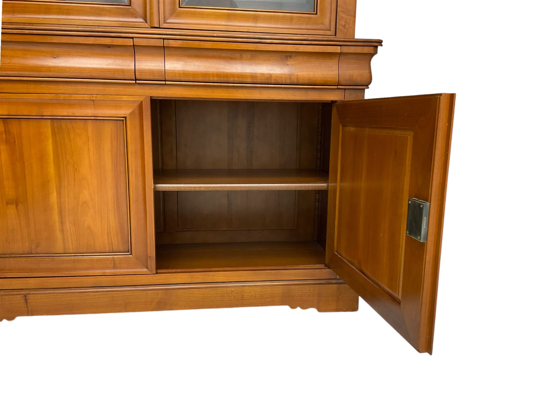 French cherry wood bookcase on cupboard, projecting cornice over two cupboard doors with bevelled glass panels enclosing three adjustable shelves, base fitted with two cushion drawers over double cupboard