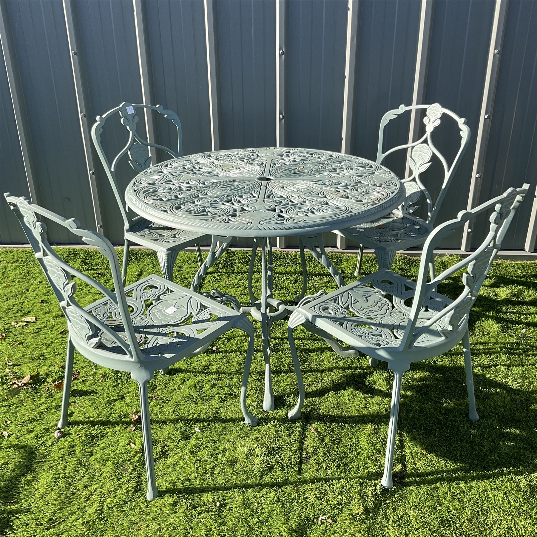 Painted cast aluminium circular garden table, and four chairs THIS