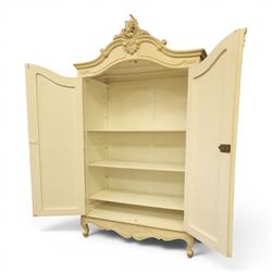 French Louis XV design cream painted double armoire, serpentine moulded pediment surmounted by carved foliate crest, enclosed by two shaped panel doors with applied scroll and leaf mouldings, enclosing a hanging rail and adjustable shelving, fluted uprights with carved floral terminals, on shaped apron and cabriole feet