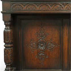 Early 20th century carved oak sideboard Jacobean style with panel back on cup and cover legs, the top section with carved panels and reeded moulding, three deep frieze drawers over triple panelled cupboard doors, raised on carved baluster legs joined by lower shelf