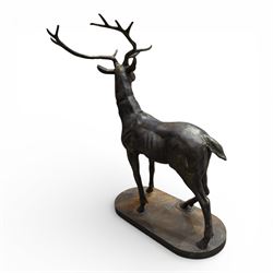 Pair of life-size cast iron garden or home stags, modelled standing upon oval plinths