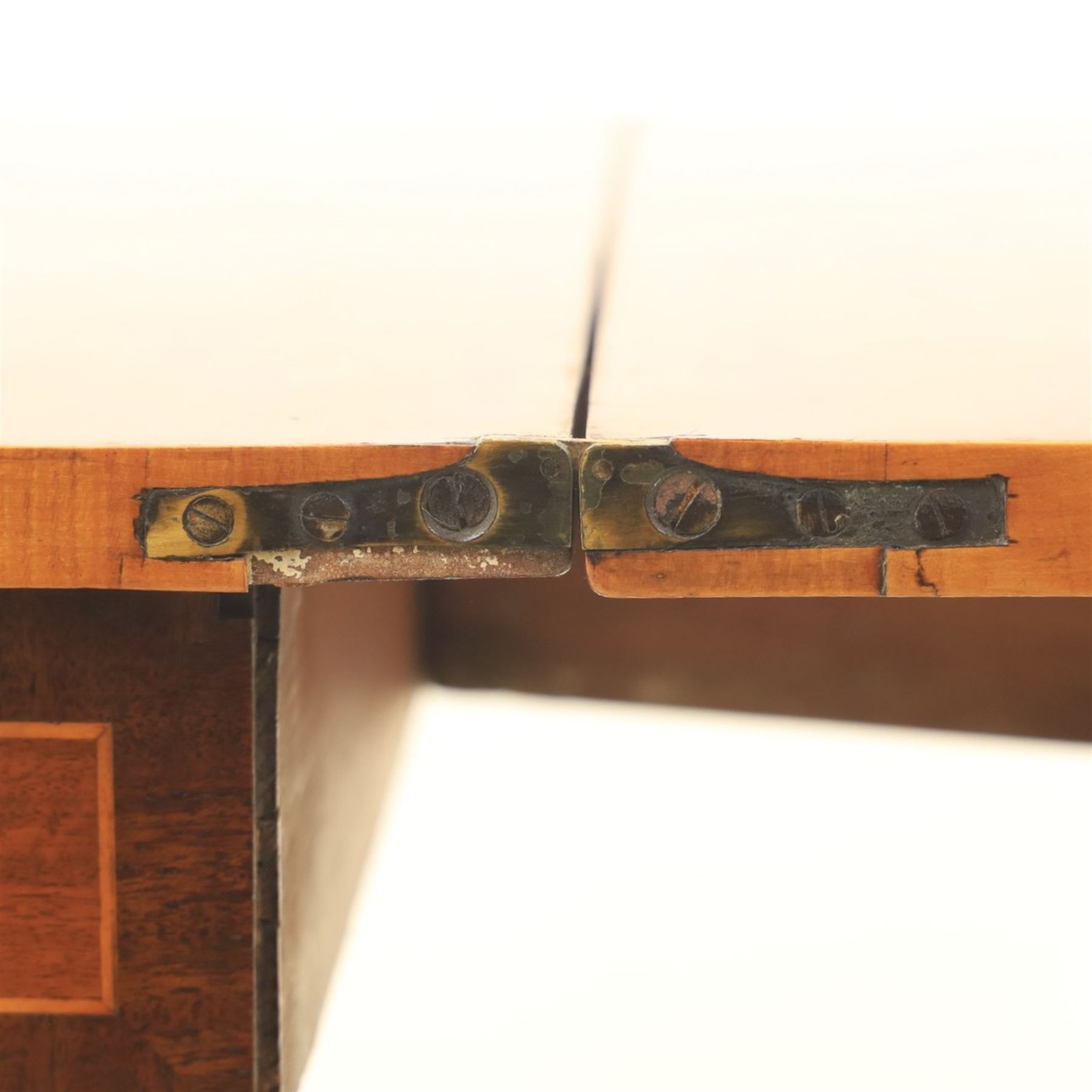 Regency mahogany fold-over tea table, rounded rectangular top with gateleg action, inlaid and crossbanded frieze, raised on squared tapering supports on brass castors