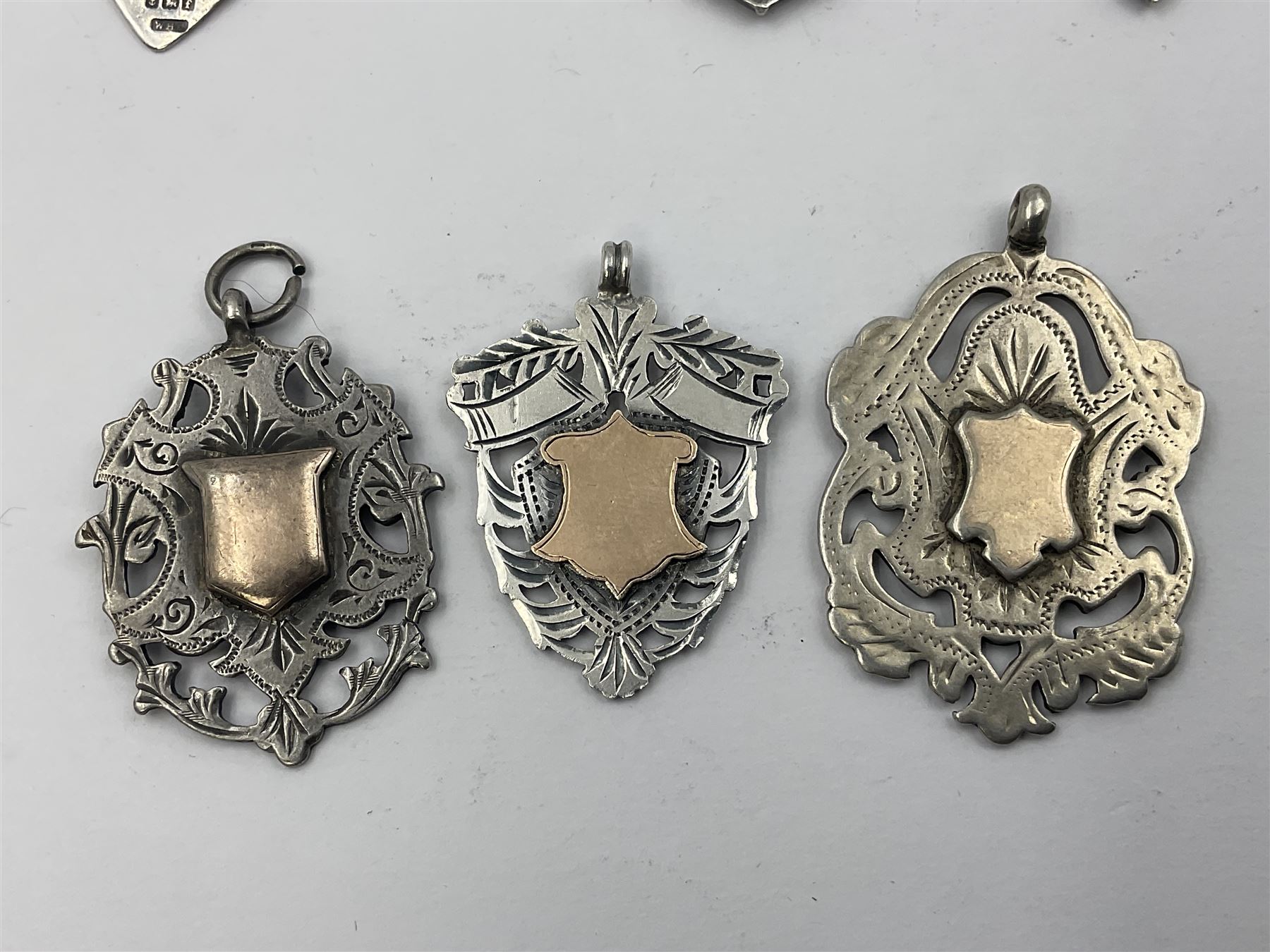 Seven Edwardian and later silver cartouche fobs, to include five gold faced examples and three double sided examples, all hallmarked with various dates and makers
