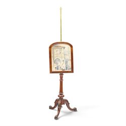 Two Victorian mahogany pole screens, comprising an oval example with floral needlework panel and carved cresting, on brass pole and tripod base with scroll carved supports (H 153cm, W 43cm, D 43cm); and a rectangular example with glazed architectural print panel, on brass pole, turned column and conforming scroll carved tripod base (H 147cm, W 38cm, D 38cm)