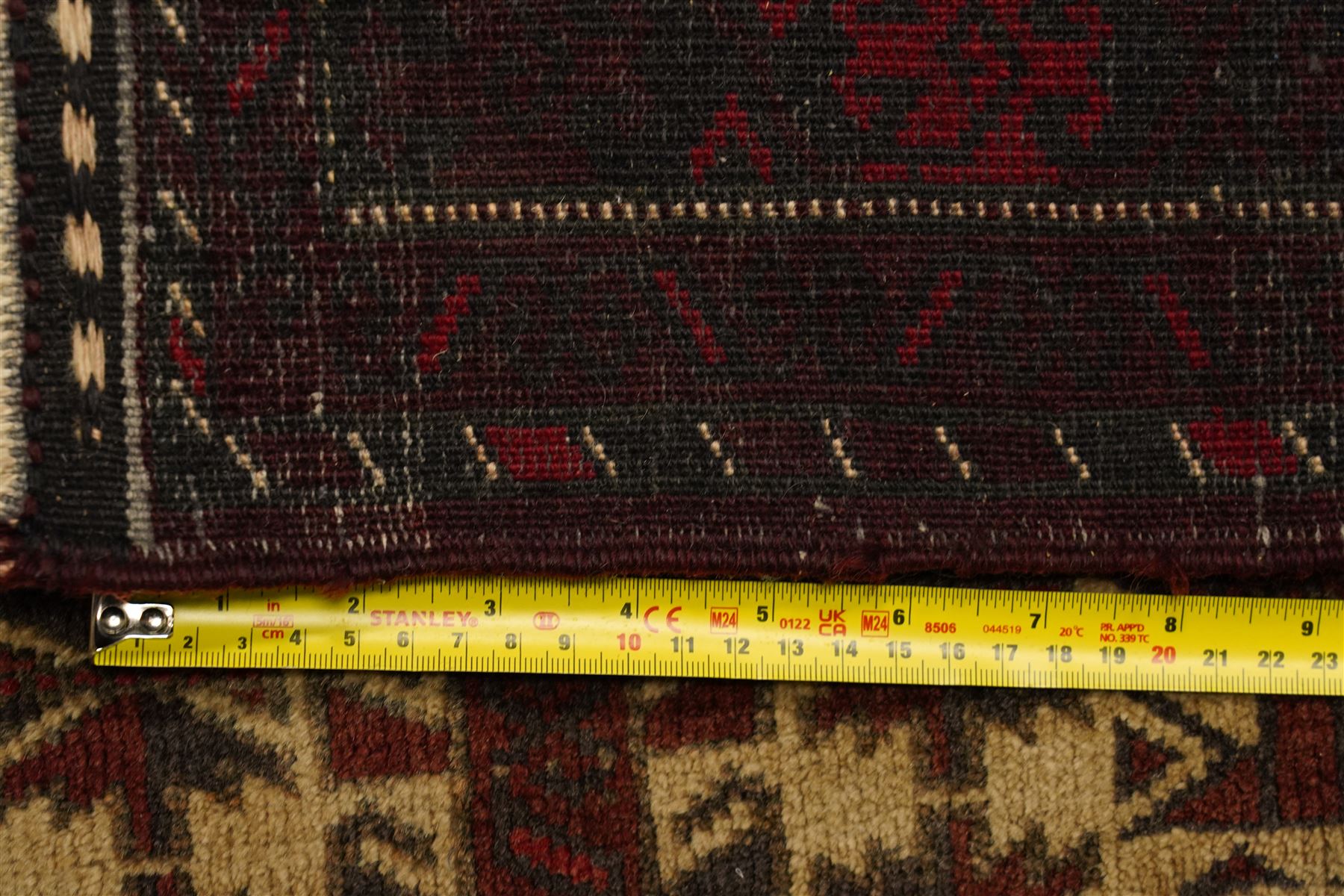 Two hand-knotted rugs, comprising Persian runner and Turkoman prayer rug, Persian hand-knotted runner, red and dark navy ground with four diamond medallions and geometric motifs, enclosed by multicoloured geometric border, striped kilim ends with fringes, H244cm, W58cm; Turkoman hand-knotted prayer rug, ivory mihrab field decorated with repeating stylised geometric motifs, enclosed by multiple geometric borders in madder red and brown, with fringed ends, H150cm, W93cm