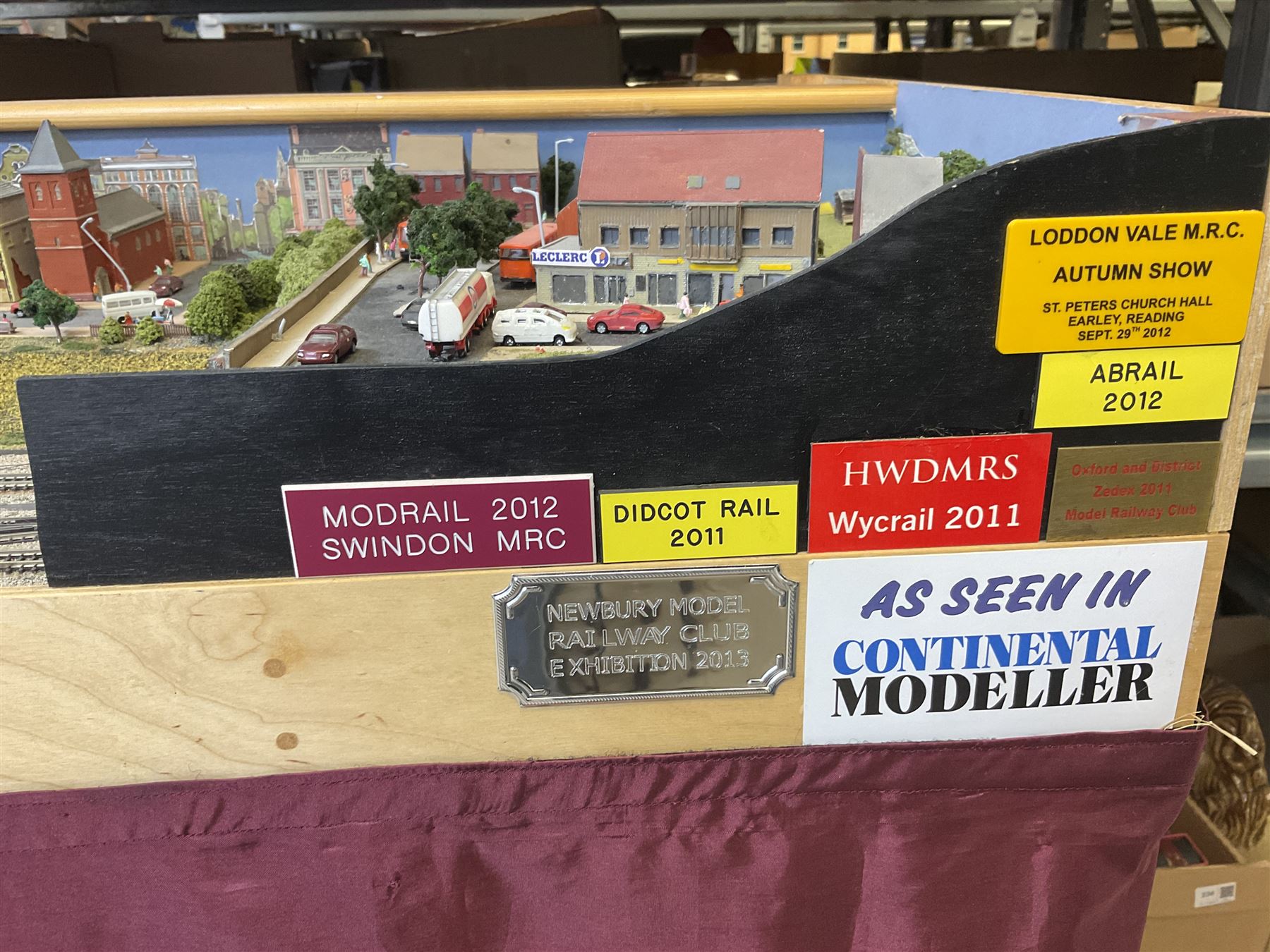 'Z' gauge continental scenic layout with folding legs, various loops of track and sidings with overhead cables, buildings including water tower, tunnels, roads with motor vehicles and figures, trees, haven with boats, backdrop diving wall hiding control units 150 x 50cm