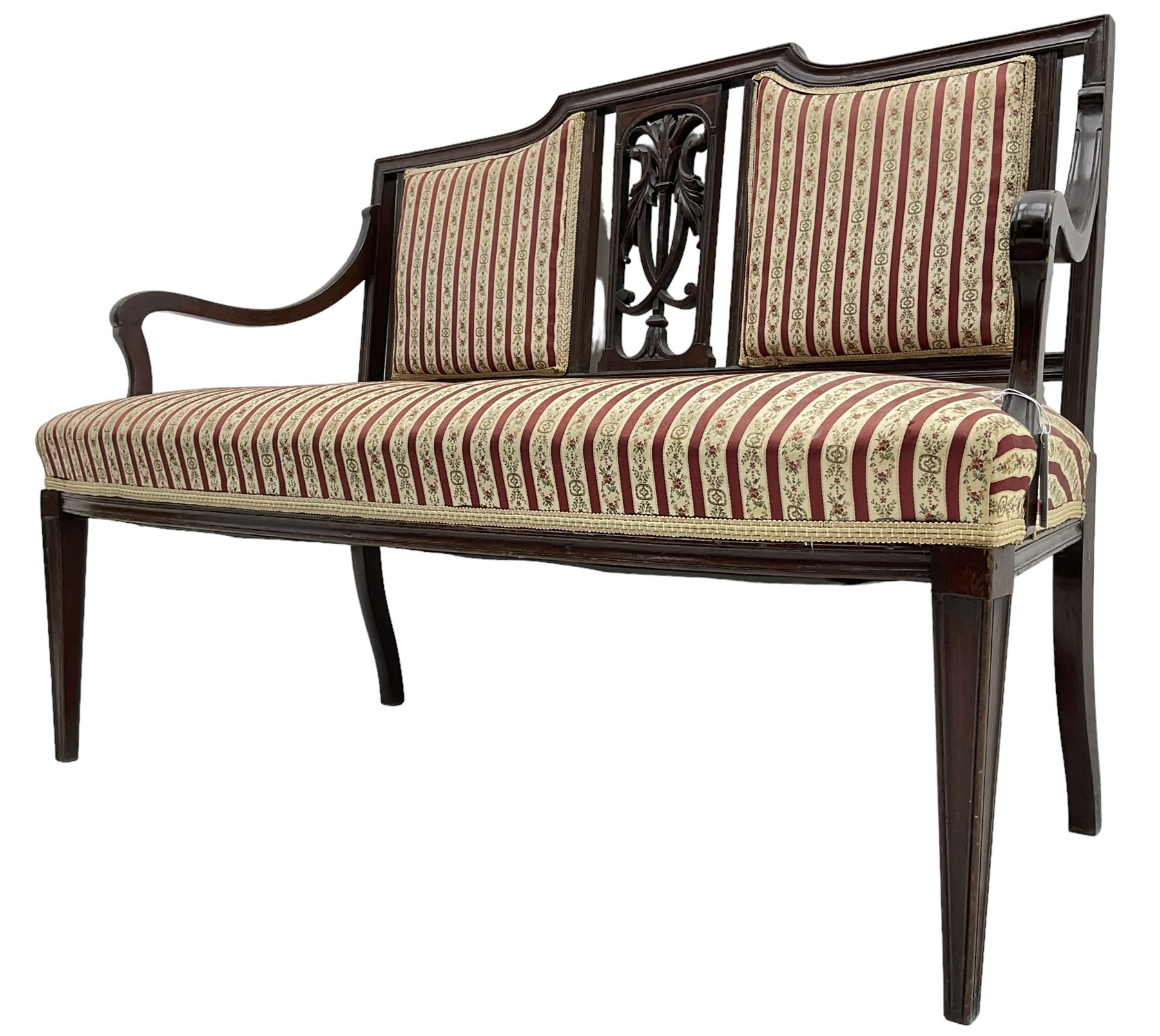 Edwardian mahogany framed three-piece salon suite - two-seat sofa, stepped cresting rail over acanthus and scroll carved pierced splat, upholstered in striped fabric (W124cm, H87cm, D62cm); and a pair of matching armchairs (W60cm) 