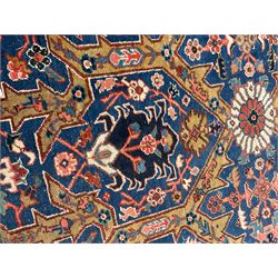 Persian blue ground carpet, the field divided up into panels by trailing bands with flower heads, each panel decorated with palmettes and stylised plant motifs, the border decorated with further palmettes, within floral pattern guard stripes 