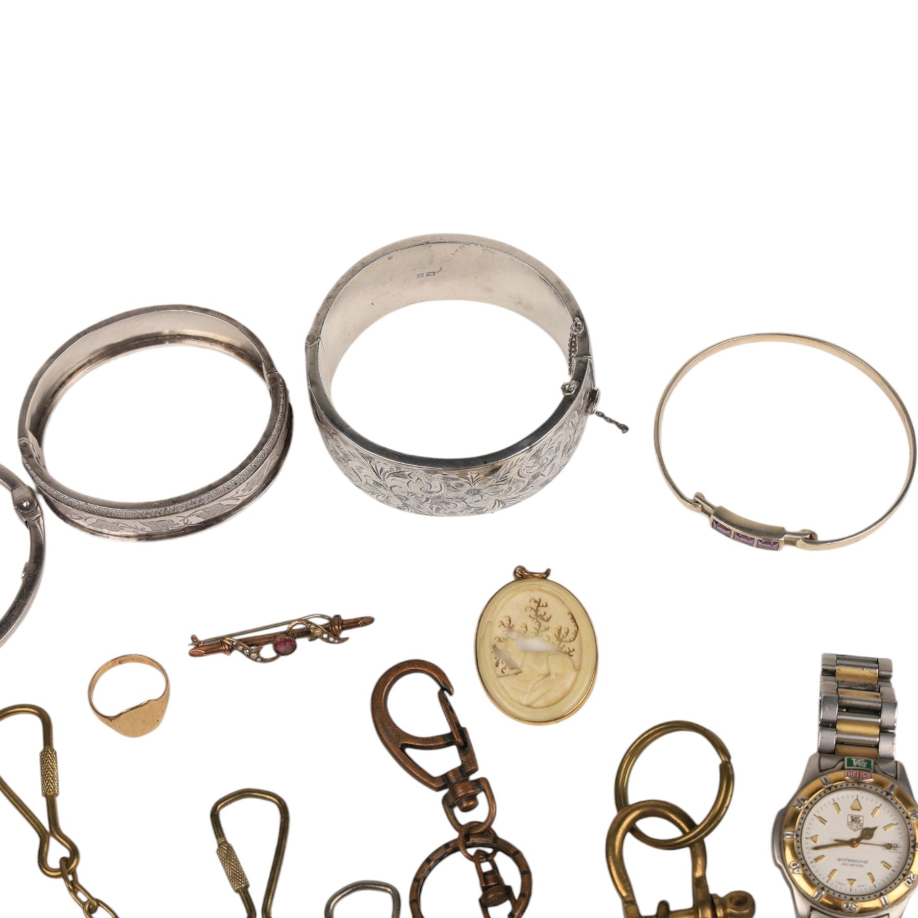 9ct gold jewellery, including bone deer pendant in gold mount, signet ring and stone set brooch, all stamped or hallmarked, three silver bangles, base metal bangle, brass diving related keychains and a Tag Heuer quartz wristwatch