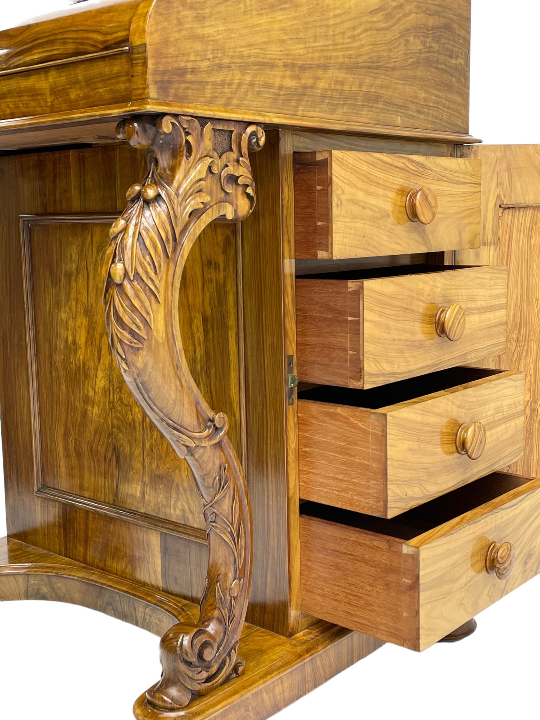 Fine and unusual 19th century olivewood piano top davenport, raised shaped back carved with olive branches and olives, the top hinges to reveal lidded and correspondence compartments, the piano lid enclosing sliding top with hinged and adjustable writing surface with leather inset, right-hand panelled door enclosing four drawers, olive branch and scroll carved cabriole front supports on moulded and shaped platform, turned cup feet with recessed castors 