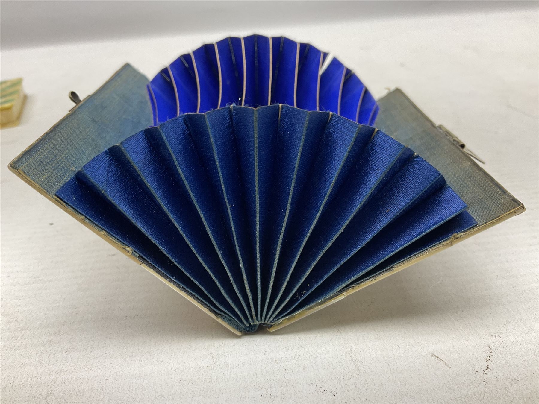 Mother of pearl and abalone inlaid card case, with central diamond shaped panel engraved with foliate decoration, together with a simulated mother of pearl card case of book form with green sun rays to cover, and simulated wood effect cigarette case with hinged lid with diamante style banding, largest L10cm