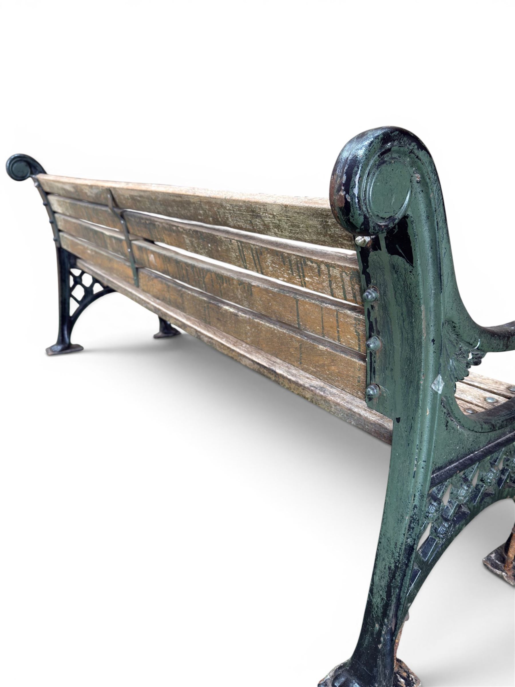 Neoclassical design cast iron and oak slatted garden bench, the twin end supports in the form of a Sphinx with acanthus carved knees and large paw feet, the pierced lattice bracket with Yorkshire rose motifs