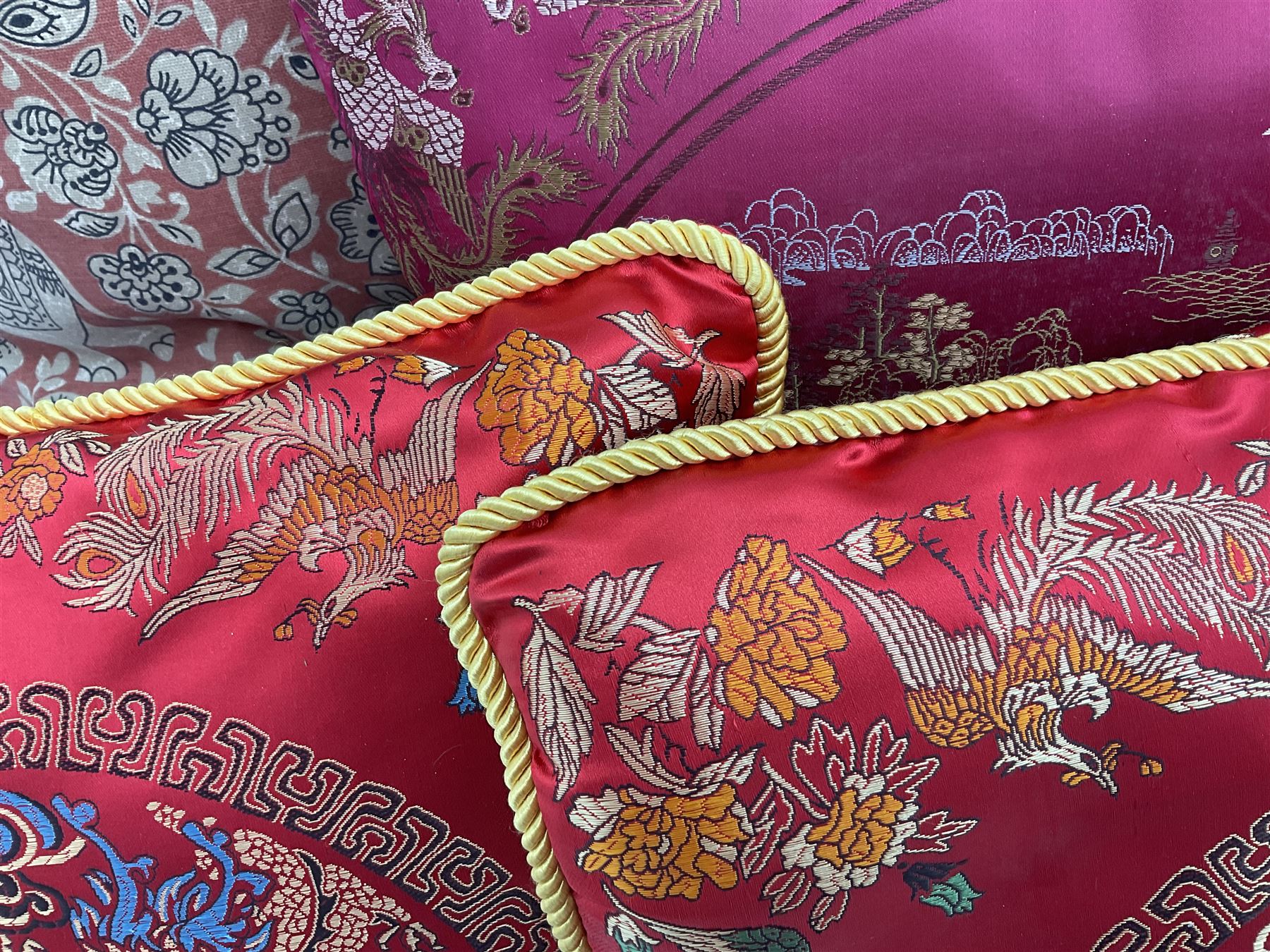 Collection of predominantly Chinese style cushions, to include feather down examples