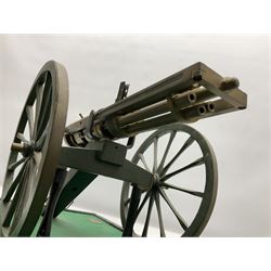 Scratch built brass model of an 1861 Gatling Gun with rotating barrels, hinged cover revealing mechanism, on metal bound wooden spoked wheels and rectangular base L47cm H22cm