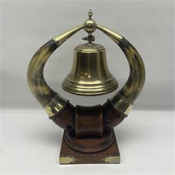 Early 20th century oak and horn dinner bell, the silvered bell suspended from a pair of cow horns, with silver plated mounts and blank shield shaped cartouche, upon square base, H37cm