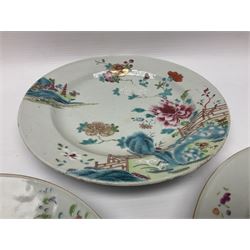 Three 18th century Chinese Famille Rose plates, the first example enamelled with blossoming peonies, rockwork and fence, the other two examples of similar design, decorated with blossoming peonies and sprigs within shaped inner borders, each approximately D23cm