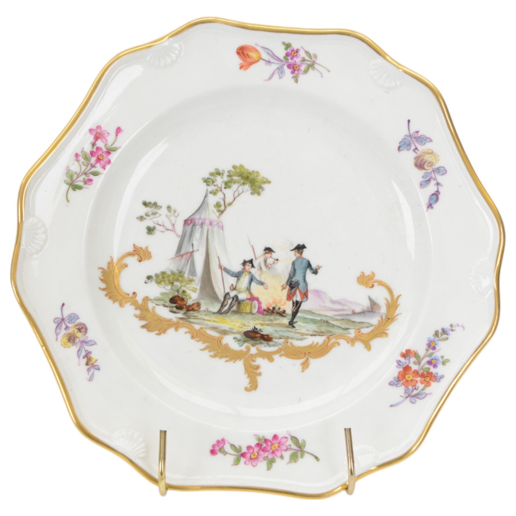 Pair of early 19th century cabinet plates, possibly Derby replacements for Frankenthal, each of faceted form with moulded shell detail to rim and gilt edge, the centre painted with an encampment with soldiers at rest, above a gold rocaille scroll and surrounded by floral sprigs to the rim, with gilt mark beneath for Frankenthal, Carl Theodor, D24cm
