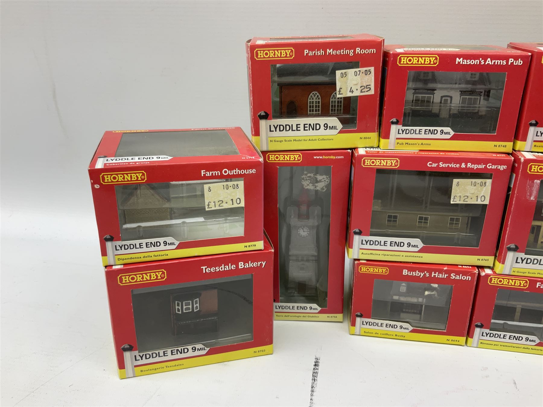 Hornby 'N' gauge - eighteen Lyddle End trackside buildings including The Old Toll House, Electricity Sub Station, Teesdale bakery, Mason's Arms Pub, various shops and hairdressers, farm buildings, Clock Tower etc; all boxed; and five Lyddle End blister pack cards of trackside accessories including Lamp Huts, Tractors, War memorial etc (23)