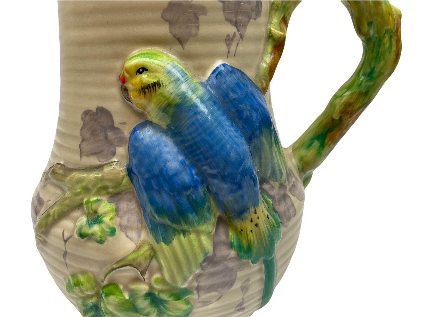 Clarice Cliff baluster jug moulded with a blue budgerigar perched upon branch with green rustic handle and mushroom glaze,  factory stamped beneath, H22.5cm