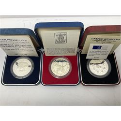 Seven The Royal Mint United Kingdom sterling silver proof crown coins, comprising two 1972, three 1977, 1981 and 1993, all cased with certificates and a Queen Elizabeth II 2001 one ounce fine silver Britannia coin on card (8)