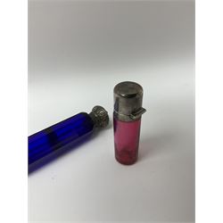 Late Victorian silver mounted ruby glass cylindrical scent bottle, with interior glass stopper, Birmingham 1900, makers mark worn, H8cm, together with a Victorian double ended cut blue glass perfume bottle mounted with white metal screw and flip caps decorated with foliate repousse detailing, H13.5cm