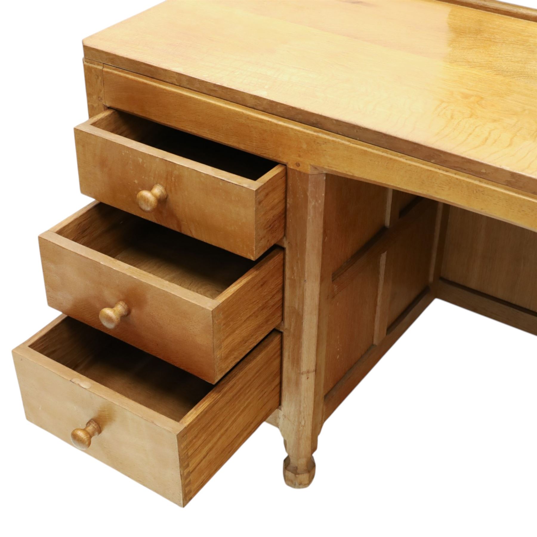 Mouseman - adzed oak kneehole dressing table with mirror, the rectangular adzed top with raised back and canted corners with fixed central pivoting mirror with scallop-carved cresting rail, over an arched recessed kneehole flanked by three graduating drawers to each side with turned knob handles, raised on octagonal feet, with carved mouse signature, by the workshop of Robert Thompson of Kilburn