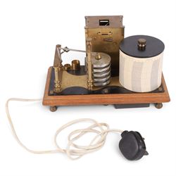 Brass barograph with integral brass clock, upon a wooden wooden plinth