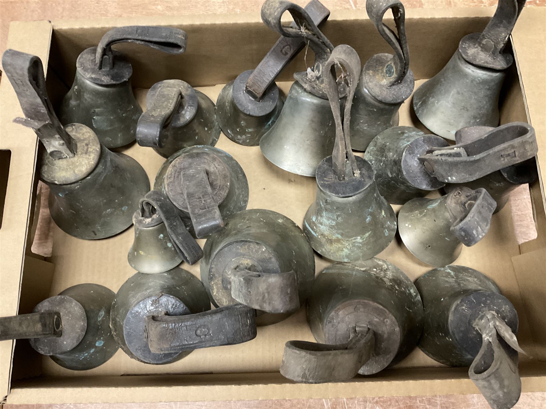 Collection of 44 late 19th century brass church/musical handbells with leather straps by James Shaw Brothers of Bradford and bells marked G.W. possibly cast by the George Welch bell foundry, London.
The number of bells and stated notation, some at different pitch, is as follows;
5 “C”, 4 “D”, 5 “E”, 4 “F”, 5 “G”, 5 “A”, 6 “B”.
3 “F#”, 4 “C#”,1 “Db”, 1 “G#”, 1”A#”.
Two of the bells are minus their clappers and one bell has no leather strap.
